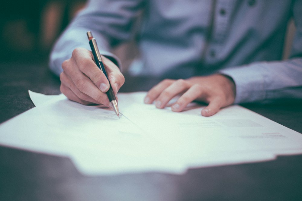 Signing a paper document with a pen