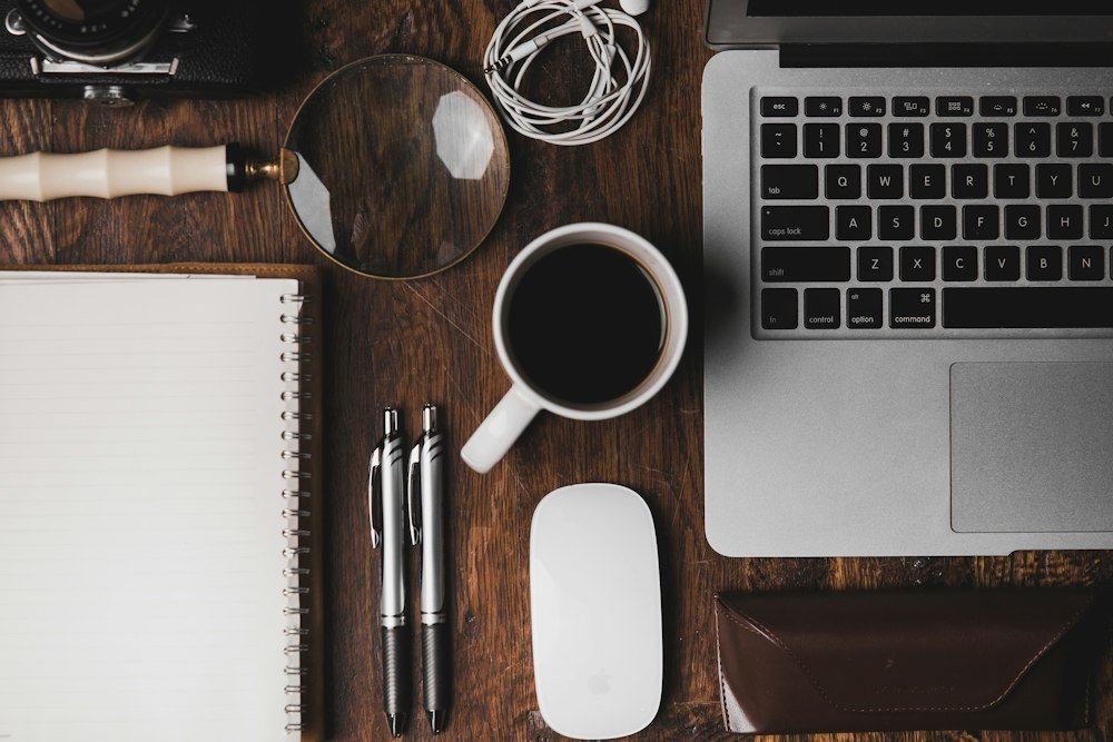 Desk with a laptop and notebook where entries are checked
