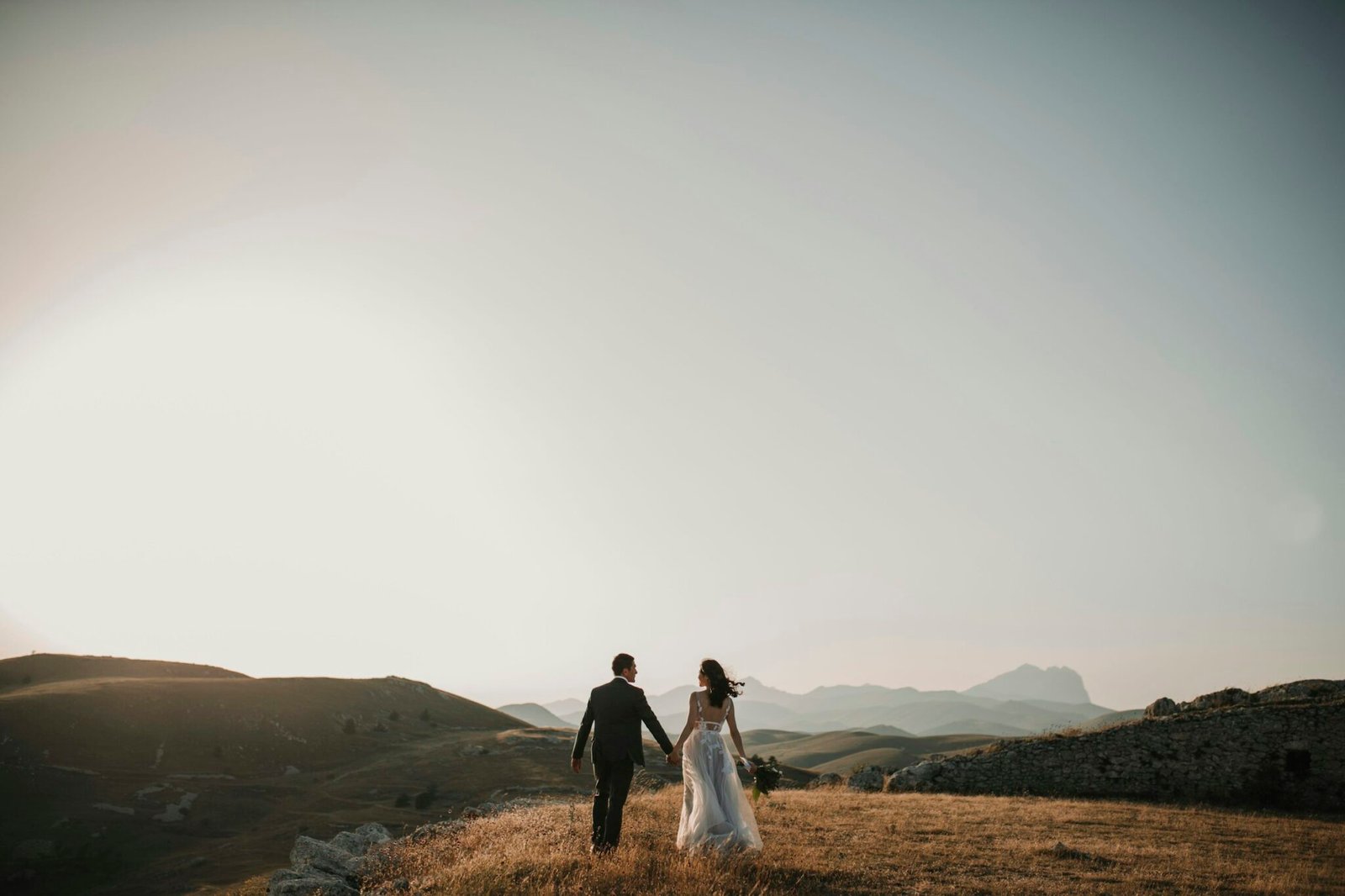Couple standing in a wide open landscape in soft light