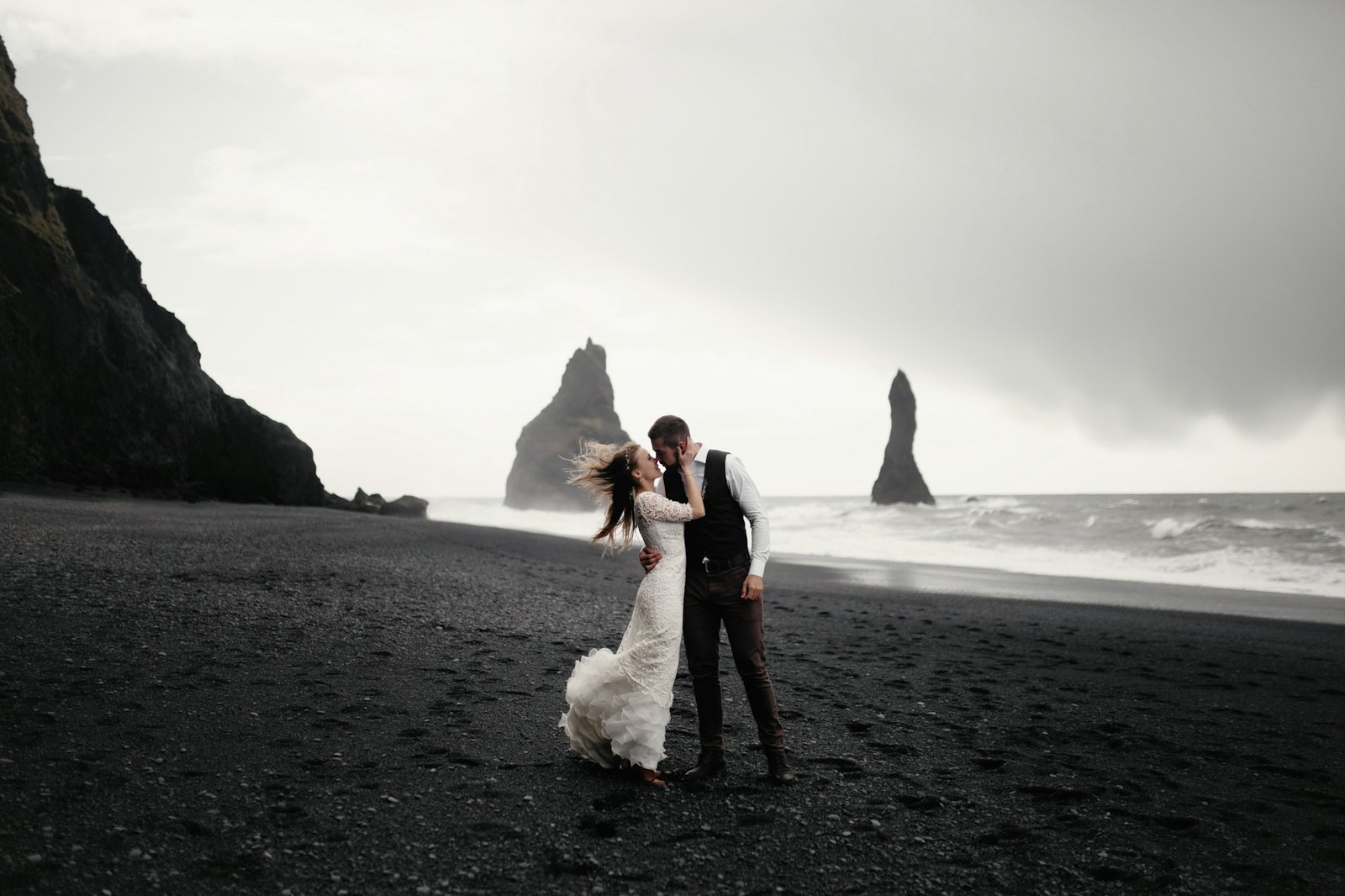 Black-and-white wedding portrait on a black-sand beach