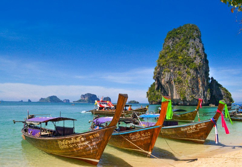 Longtail boats below limestone cliffs, Thailand