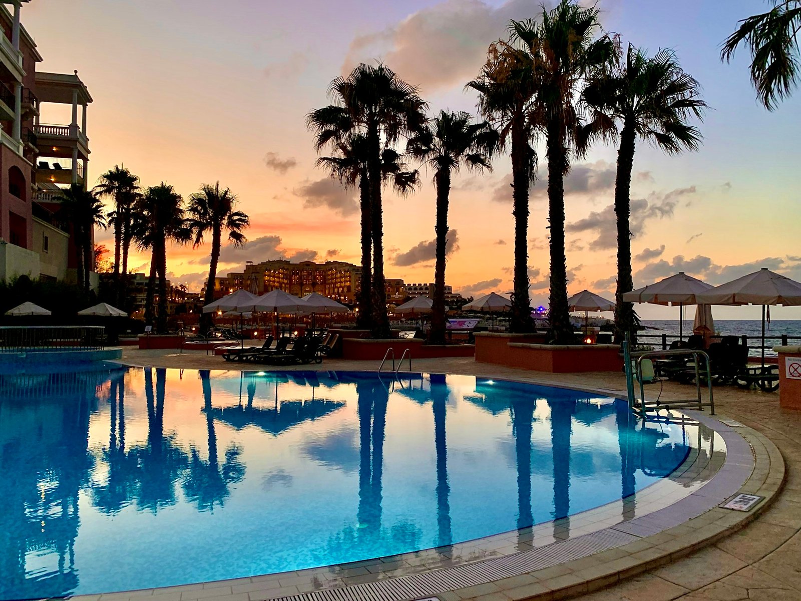 Palms and a pool at sunset in Cyprus