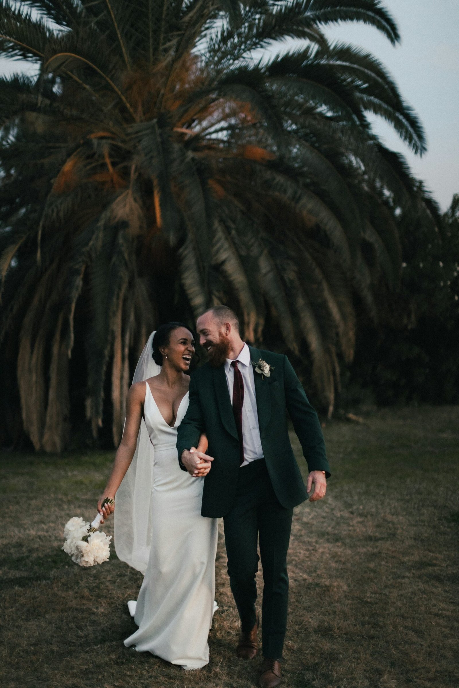 Wedding couple walking under palm trees
